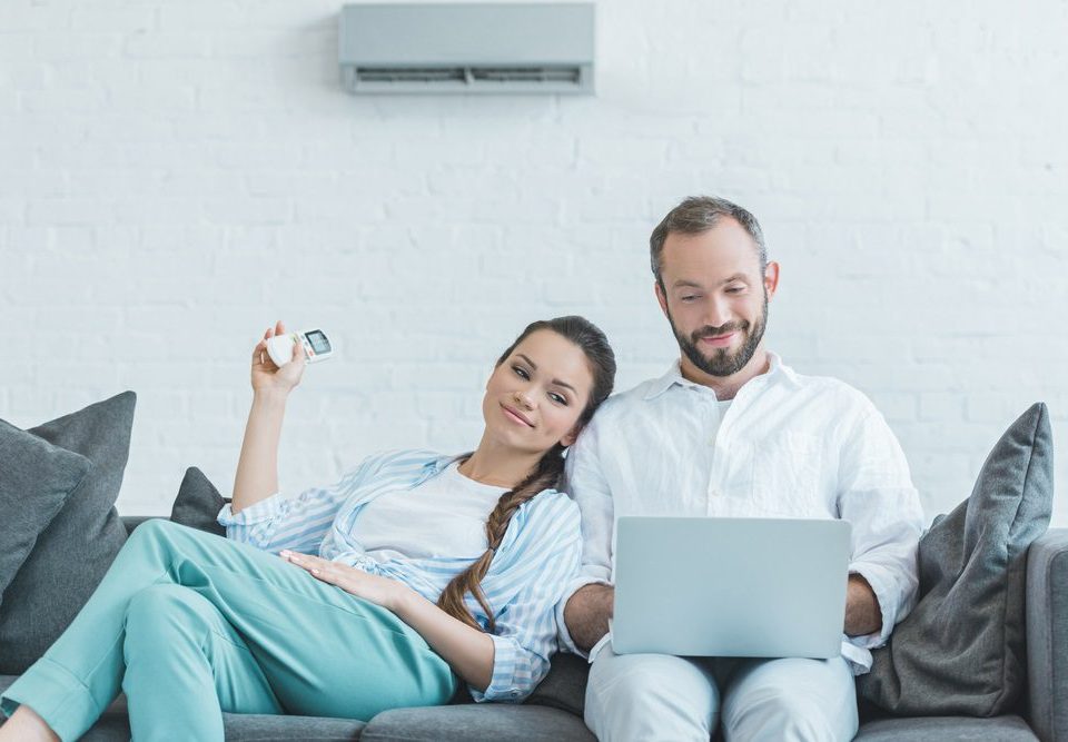 Pareja que enciende el aire acondicionado durante el calor